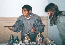 Local artisan working in the atrium of the Municipal Palace museum (Cusco, Per�) who hand paints pottery pieces, wind instruments, chess sets, and other crafts, a many of which I bought for eight American dollars (Guilia Davis looks on)