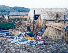 On a floating island (made of bound reeds) near Puno, Per� on Lake Titicaca, a hopeful Uro (Indian) woman sells crafts and hand made textiles to visitors