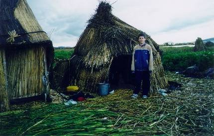 Joshua al lado de las casas de los Uros en una isla flotante en el Lago Titicaca (feb. 2000)