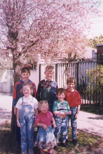 Joshua, David, Daniel, Grace, Rachel y Matthew al lado de un arbol cerca de su casa en Santiago, Chile (agosto de 1998)